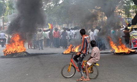 Indian children look on as activists burn tyres during a statewide strike in Bangalore in September 2016.