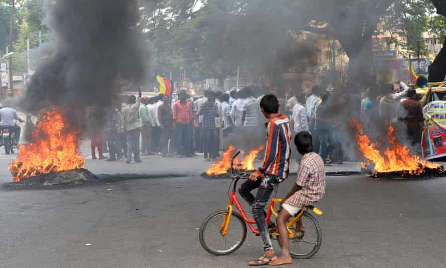 Indian children look on as activists burn tyres during a statewide strike in Bangalore in September 2016.