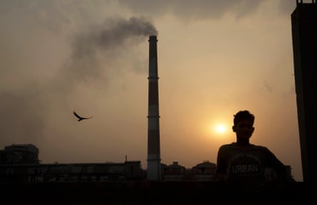 Emissions bellow from smokestacks at sunset