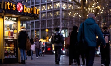 People walk near a doner kebab and currywurst stall in Berlin.