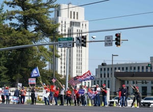 Supporters of Donald Trump hold signs and wave flags outside Walter Reed medical center in Bethesda, Maryland, on 4 October.