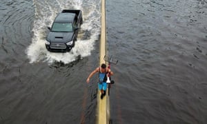 A man walks on a highway divider while carrying his bicycle in the aftermath of Hurricane Maria in San Juan, Puerto Rico in 2017.