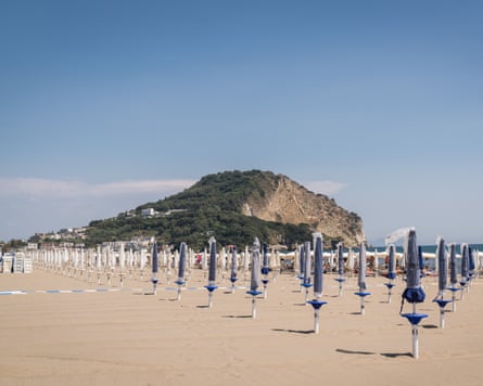 Empty beach with rows of closed parasols
