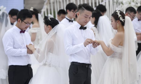Newlywed couples attend a group wedding ceremony at Juzizhou Island Landscape in Changsha, Hunan Province of China in May 2020.