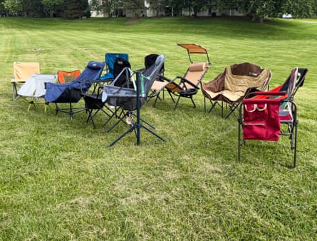A collection of camping chairs photographed in a field