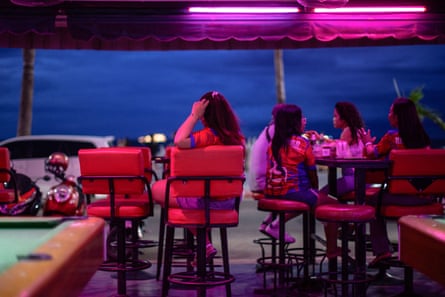 Employees rest as they wait for customers in a bar near Pattaya Beach.