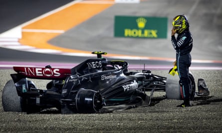 Lewis Hamilton stands by his damaged car.