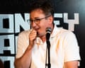 Comedian Chris Cantrill laughs while speaking into a microphone on stage