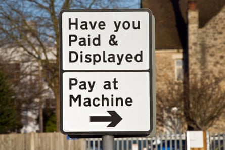 Signs in a car park reminding motorists to pay for using the carpark, and the location of the machine.