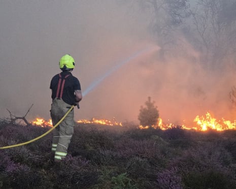 A firefighter tackling the blaze with a water hose
