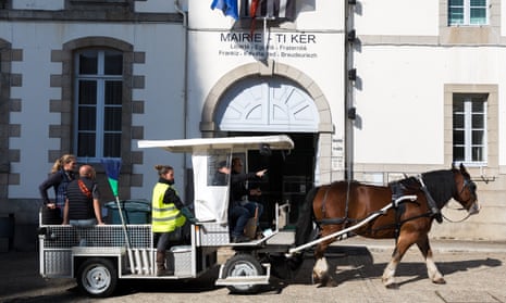 Dispar, a Breton draft horse, pulls refuse collectors in Hennebont, Brittany.