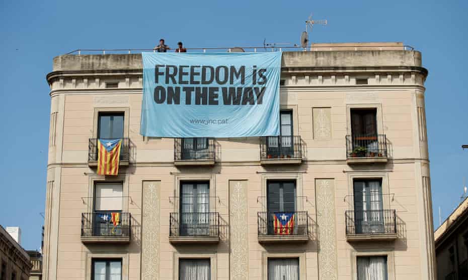 Catalonia independence supporters unfurl a banner on a building next to the Palau de la Generalitat, the regional government headquarters, in Barcelona, on Friday.