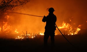 A firefighter battling a bushfire on the NSW south coast on Thursday. Smoke from the fires will contribute to a massive global rise in carbon dioxide concentrations in the atmosphere.