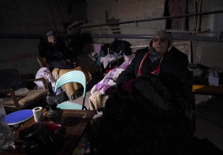 Civilians huddle on a basement floor.