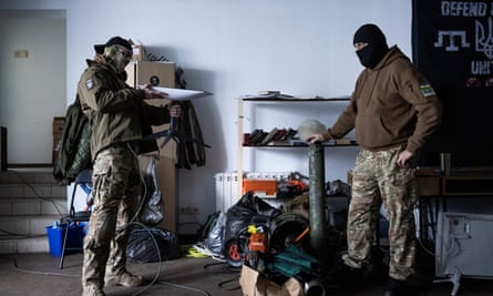 Tor (R) leans on a machine gun tripod and Maga (L) holds a Starlink plate at a Chechen base in Kiev