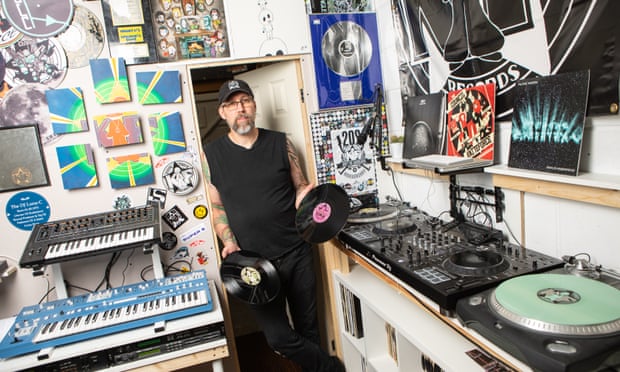 Producer and DJ Chris Howell, also known as Luna-C, in his studio, holding two vinyl records.