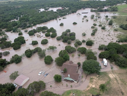 Houses and cars are partially submerged in flood waters in an aerial view near Kerrville, Texas.