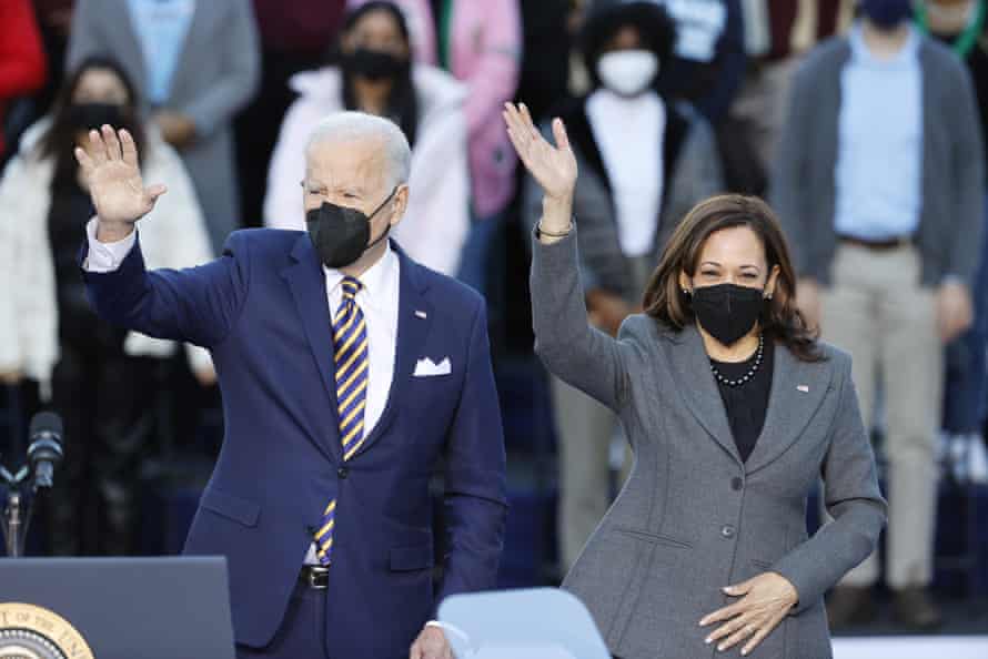 Joe Biden and Kamala Harris, both wearing masks, wave to the crowd