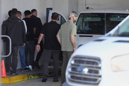 Plainclothes agents load detained people into a van