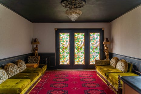 decorated living room area with couches, lamps and stained glass windows