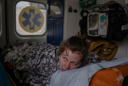 Karina (30), menunggu untuk diangkut dengan kereta evakuasi dan diangkut ke rumah sakit di Lviv.  Karina mengalami cedera punggung yang parah selama penembakan Rusia di desanya Borivske dekat Sievierodonetsk.  Dia hanya bisa berbaring telungkup.