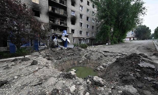 A shell crater in front of a damaged residential building in the town of Siversk, Donetsk Oblast.
