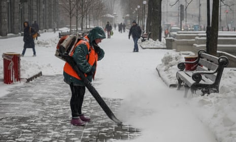 A municipal worker removes snow in central Kyiv.