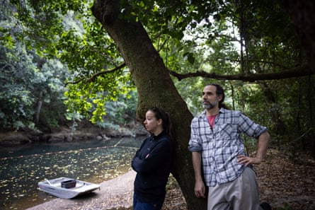 Dr Tahneal Hawke and Dr Gilad Bino lean against a tree trunk by a river