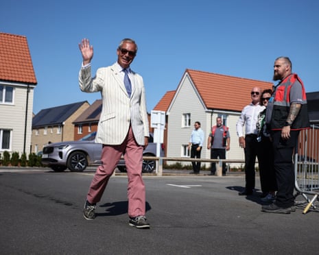 Farage in suit and sunglasses waving as he arrives at polling station