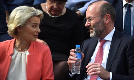 Von der Leyen and Manfred Weber speaking to one another. He is holding a plastic water bottle