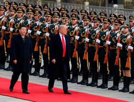 Donald Trump and Xi Jinping walk along a line of Chinese military personnel