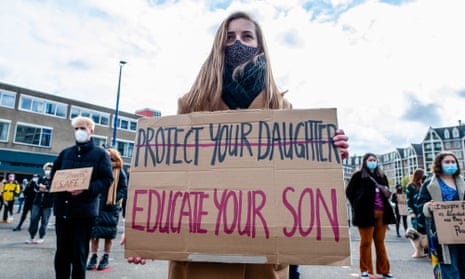 Woman holds sign reading ‘Educate your son’