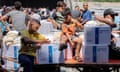 Boys sit on a cart with humanitarian aid packages provided by the United Nations Relief and Works Agency for Palestine Refugees (UNRWA) in central Gaza