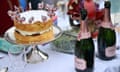 A Victoria sponge cake and bottles of Rose wine are pictured on a table. 