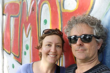 The couple in front of street art saying 'Timor'