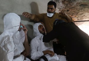 A man breathes through an oxygen mask as another one receives treatment.
