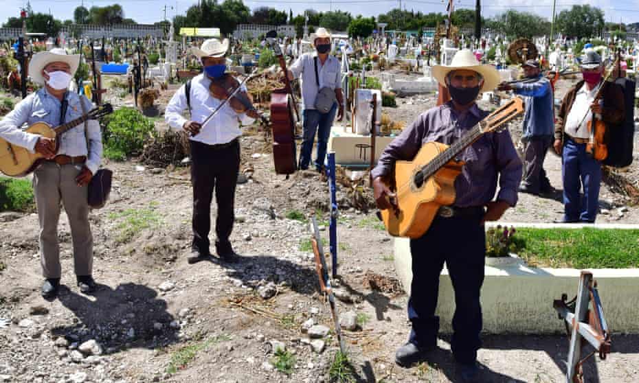 Musicians from the group Los Tigres de la Guasteca sing to the deceased in the pantheon of San Isidro, in the municipality of Ecatepec, Mexico.