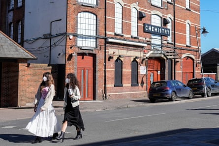 Two women walking on the street past Club Chemistry