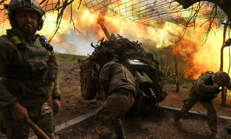Ukrainian service personnel fire a howitzer towards Russian troops at a position in a frontline near the town of Soledar in Donetsk oblast