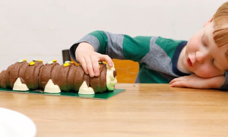 A little boy with Colin the Caterpillar cake.