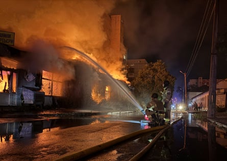 firefighters aim hose at fire at a residential building
