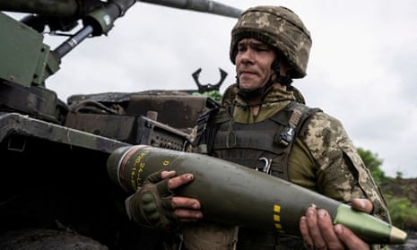 A Ukrainian service member carries a shell for a Caesar self-propelled howitzer.