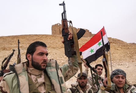 Syrian government army soldiers hold up a Syrian national flag near Fakhr al-Din al-Maani Citadel