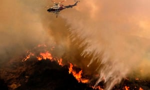 A helicopter drops water to a brush fire at the Holy Fire in Lake Elsinore, California, on Saturday.