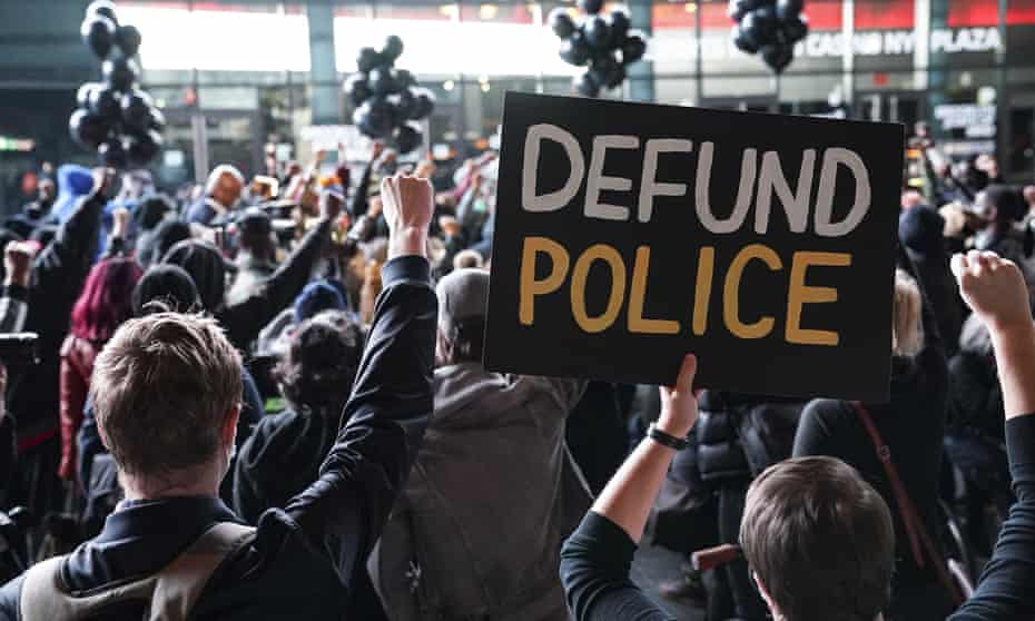 A protester holds a ‘Defund Police’ sign during a rally for the late George Floyd outside Barclays Center in New York on 14 October.