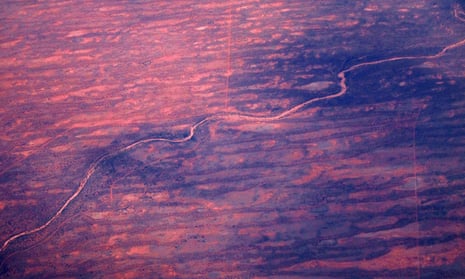 A dried-up river can be seen next to sand dunes and salt pans in outback Australia.