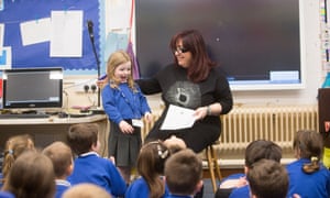 A year 1 girl calling the register while standing next to her Italian teacher