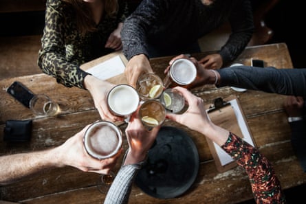 Ci-dessus, photo d'un groupe d'amis dans un pub, partageant un toast.