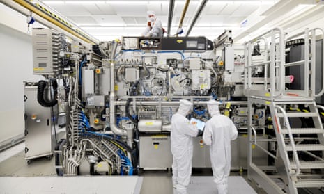 Employees working on the final assembly of an ASML semiconductor lithography tool with its panels removed, in Veldhoven, Netherlands, in 2019.