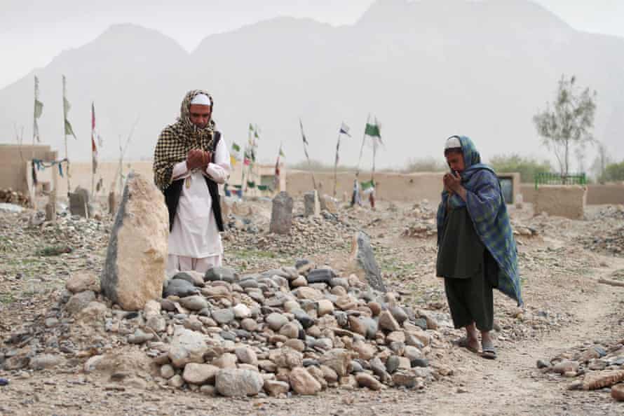 Des villageois afghans prient sur la tombe de l'une des seize victimes tuées lors d'une fusillade par Robert Bales.